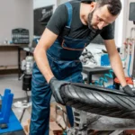 Borracheiro em sua oficina fazendo uma troca de pneu de moto