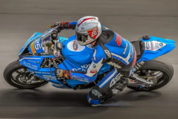 Pilode de moto em uma pista de corrida em sua moto azul
